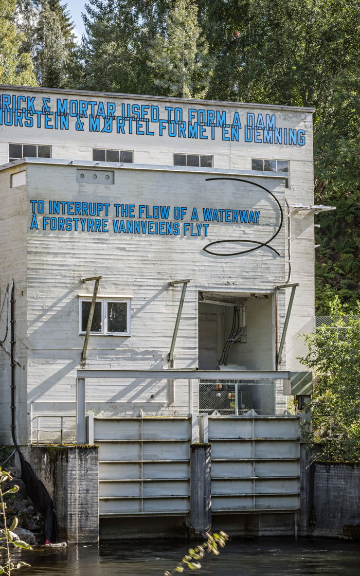 Industrial building. Blue sculptural text. Artwork.